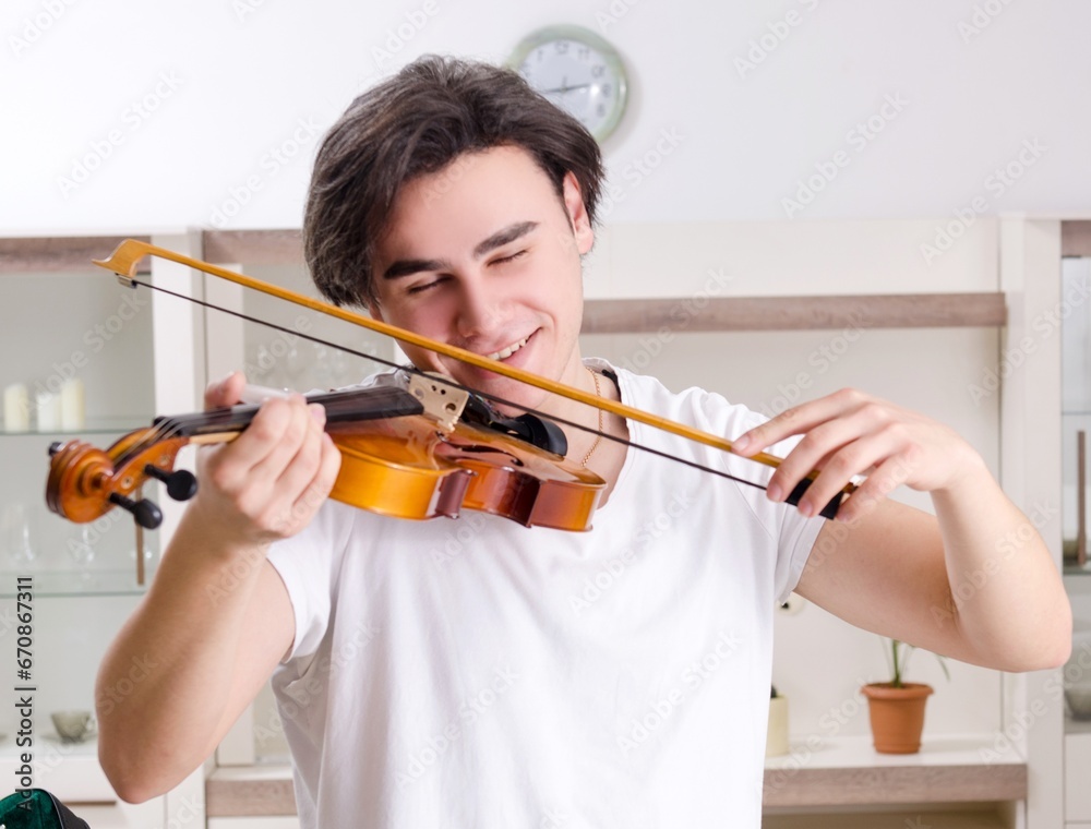 Young musician man practicing playing violin at home Young musician man practicing playing violin at home