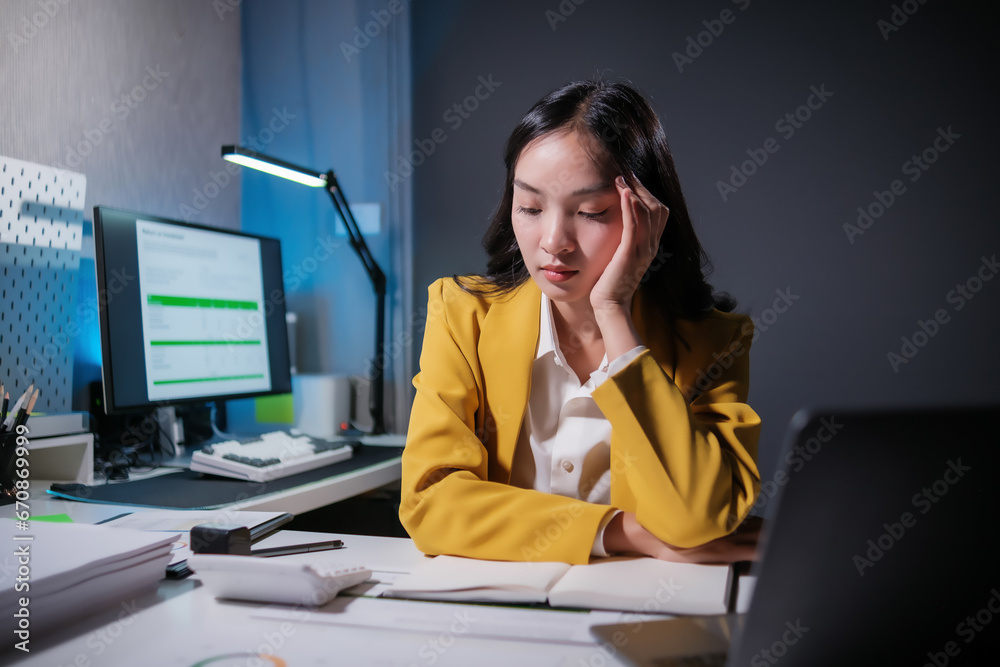 Stressed business woman working in office on laptop looking worried, tired and overwhelmed. Stressed business woman working in office on laptop looking worried, tired and overwhelmed.