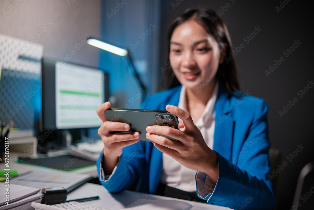 Smiling blonde woman using laptop and smartphone while sitting