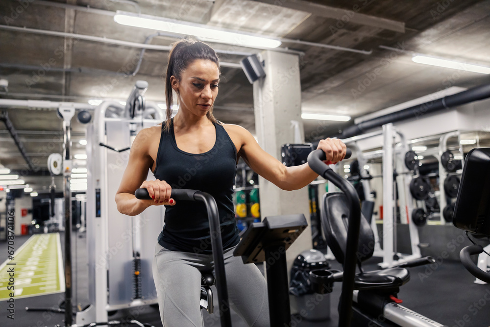 A sportswoman is doing workouts on a elliptical exercise machine. A sportswoman is doing workouts on a elliptical exercise machine.