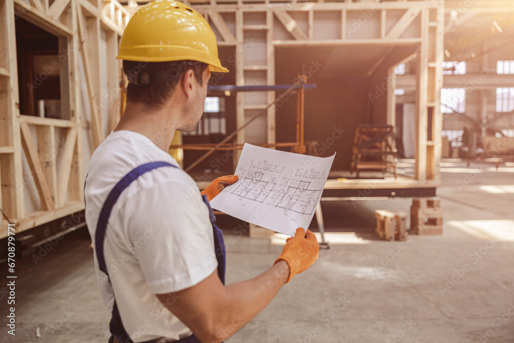 Male builder working with architectural plan at construction site Male builder working with architectural plan at construction site
