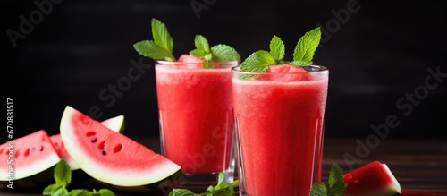 Glasses filled with a watermelon smoothie and garnished with mint leaves make for a refreshing summer drink The juice is freshly squeezed and the overall drink is a healthy vegetarian option