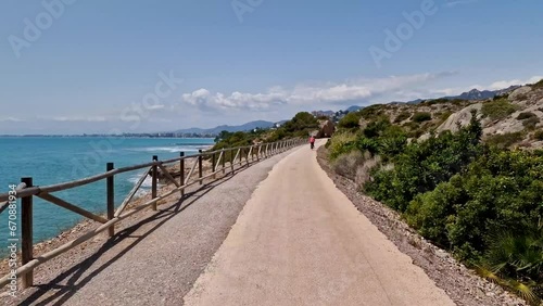 Green path on the coast of Spain in spring. Province of Castellon. Rocks and turquoise sea with waves. Favorite place for active walks. Oropesa del Mar