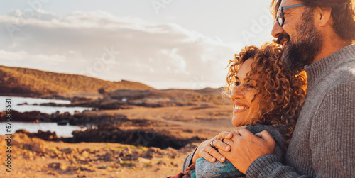 Happy couple hugging and enjoying travel destination. together with smile and serene expression. One man embrace woman from behind. Concept of traveler vacation lifestyle. Sunny portrait of people photo