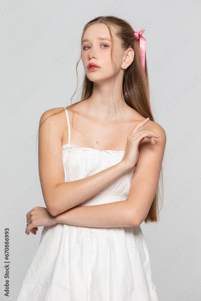 Portrait of a cute romantic young seventeen year old girl on a gray background. Portrait of a cute romantic young seventeen year old girl on a gray background.