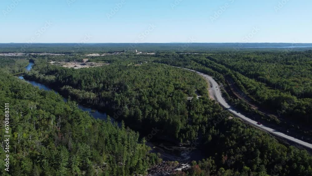 Canadian forested landscape with winding highway and distant clearing Canadian forested landscape with winding highway and distant clearing
