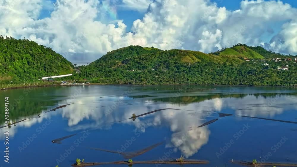 A time lapse of clouds moving above a perfectly still, aquaculture fish pond, used to farm shrimp in Surigao - Philippines. Still shot, daytime. A time lapse of clouds moving above a perfectly still, aquaculture fish pond, used to farm shrimp in Surigao - Philippines. Still shot, daytime.