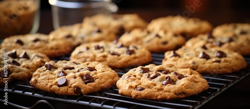 Horizontal view of a metal cooling rack holding freshly baked chocolate chip oatmeal cookies