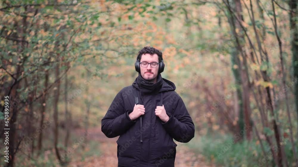 Joyful bearded European man with trendy glasses stands amidst the hues of a mixed autumn forest, radiating happiness and warmth upon seeing viewers, emanating pure positive vibes. Joyful bearded European man with trendy glasses stands amidst the hues of a mixed autumn forest, radiating happiness and warmth upon seeing viewers, emanating pure positive vibes.