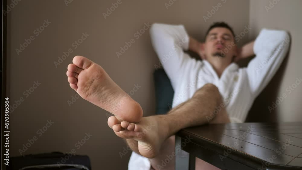 relaxation after a bath, a young man moves his feet after cosmetic procedures in the bathroom relaxation after a bath, a young man moves his feet after cosmetic procedures in the bathroom