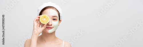 beautiful happy woman with facial skin care mask holding orange isolated on white banner