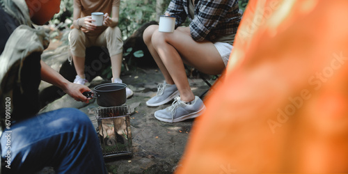 Close-up of Boiling Water with a Camp Stove of a Young People Trekking Group while Sitting Relaxed in the Rainforest and Campsite Drinking Coffee and Water. Banner with Copy Space.