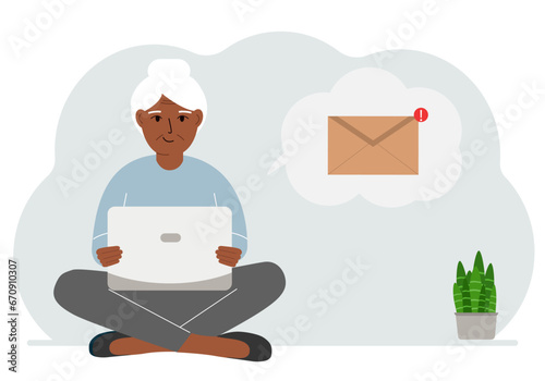 A woman sits cross-legged working with a laptop and opens an email. The concept of education, work, correspondence.