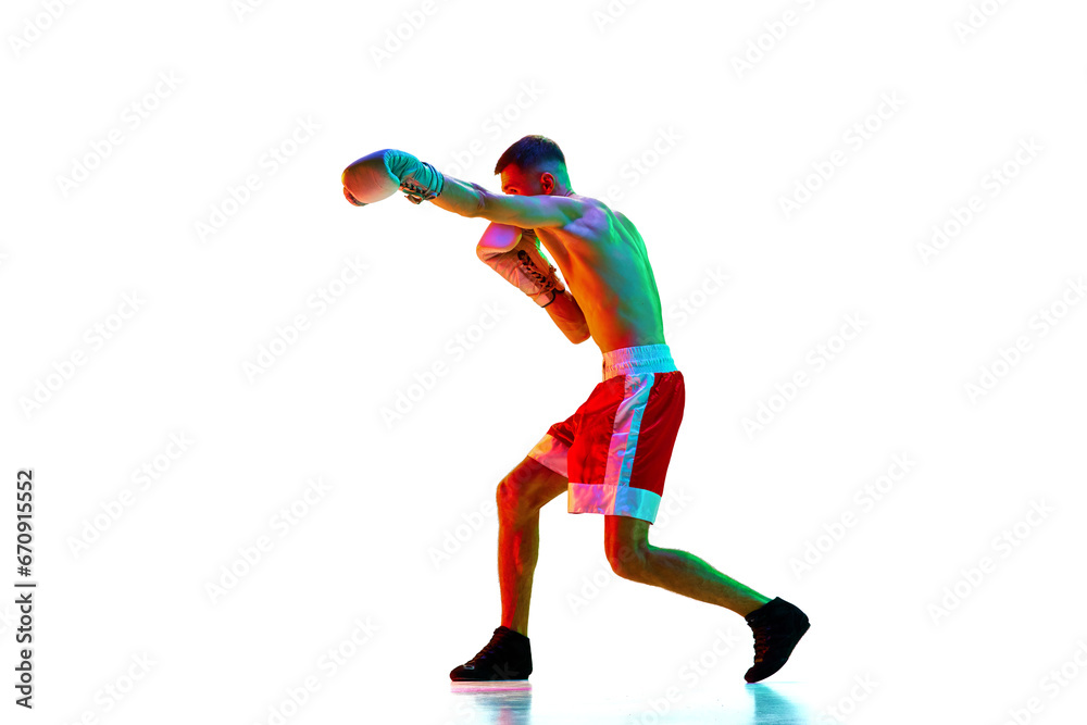 Side view. Active shirtless male boxer, mixed martial art fighter workout against white background in mixed neon filter, light.