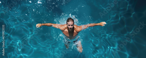 Swimmer man in water top view. Man swimming in pool aerial view.