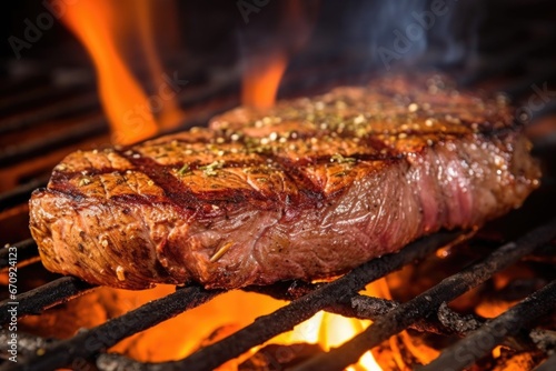 a close view of a seasoned steak over direct fire