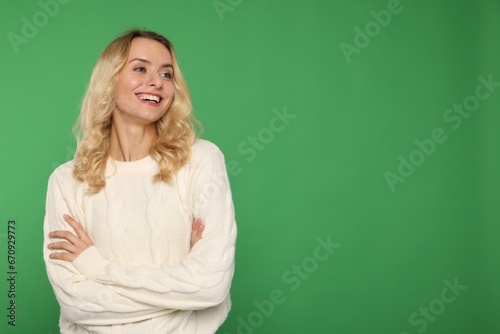 Happy woman in stylish warm sweater on green background. Space for text © New Africa