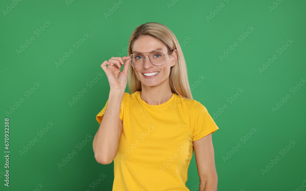 Portrait of smiling woman in stylish glasses on green background Portrait of smiling woman in stylish glasses on green background