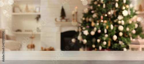 Empty white wooden table in room with Christmas tree and fireplace. Banner with space for design