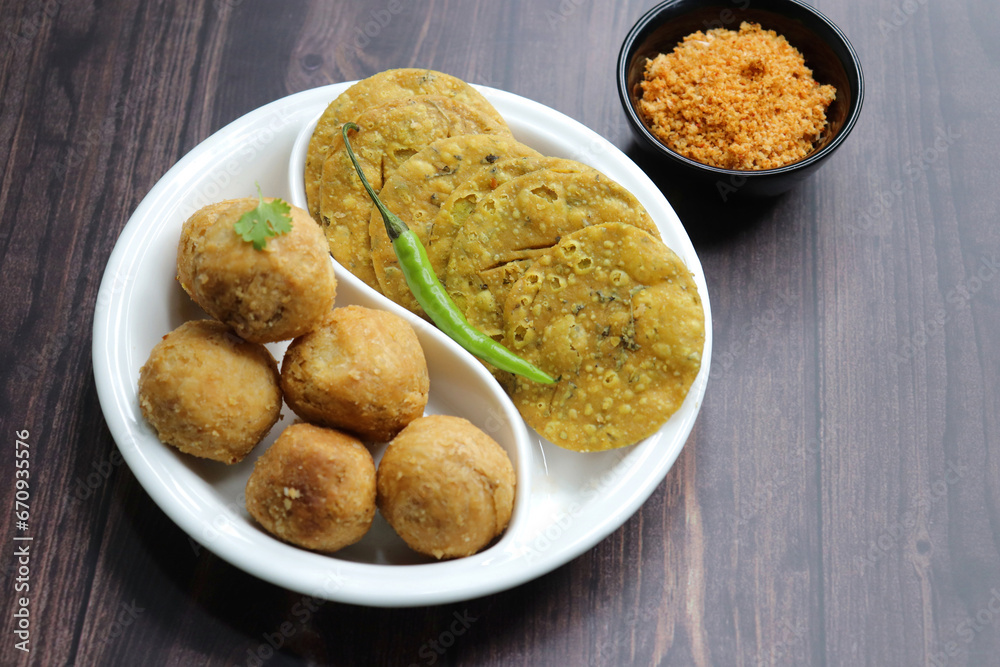 Indian popular snacks plate Dry Kachori and methi mathri. made using maida flour, a spicy mix of gram flour, sev, Lentils, Tamarind chutney and other Indian spices. A popular tea time snack. 