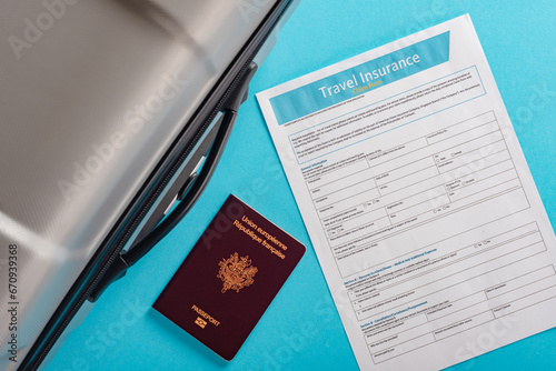 Travel bag with french passport and insurance form isolated on blue background