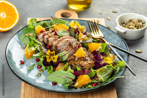 Duck salad with grilled breast and vegetables on plate on a light background top view. place for text