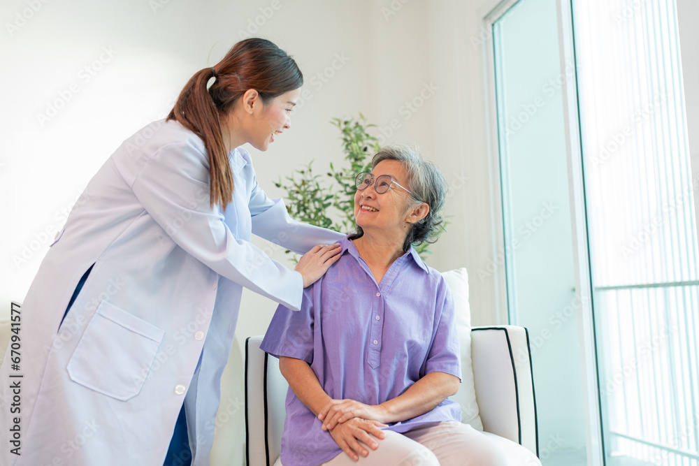 Fototapeta premium Asian female doctor taking care and talking mature female patient sitting on sofa in hospital. Healthcare concept.