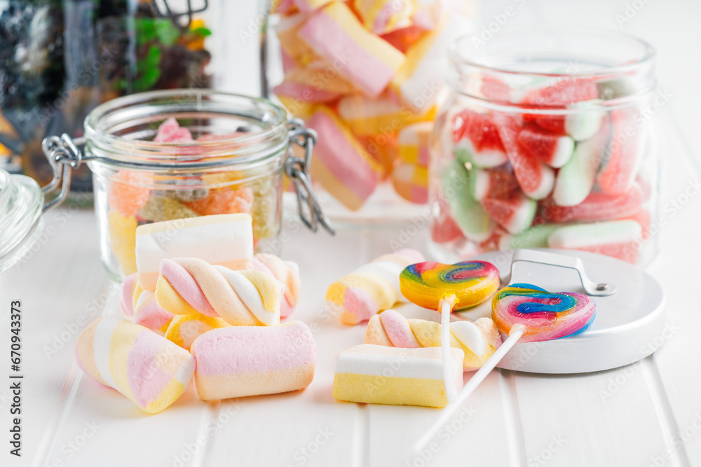 Sweet colorful marshmallows and jelly candies on white kitchen table. Sweet colorful marshmallows and jelly candies on white kitchen table.
