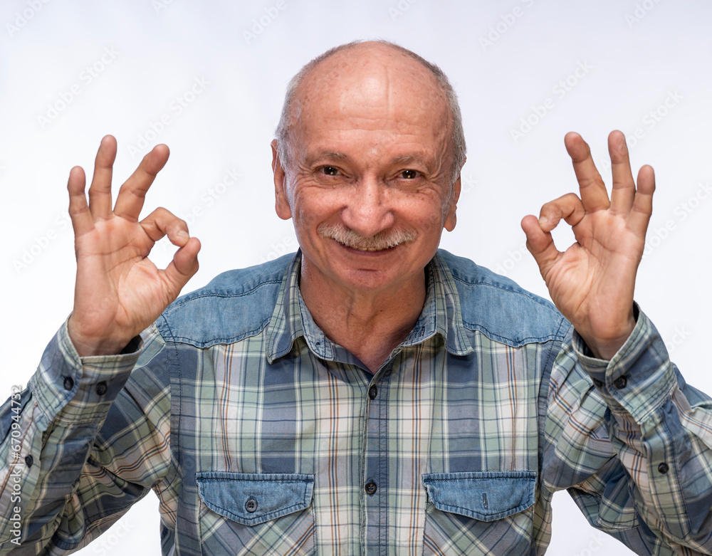 Portrait of positive senior man posing in studio