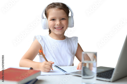 Smiling little girl in headphones handwrite study online using laptop on a transparent background, cute happy small child in earphones take Internet web lesson or class on PC. photo