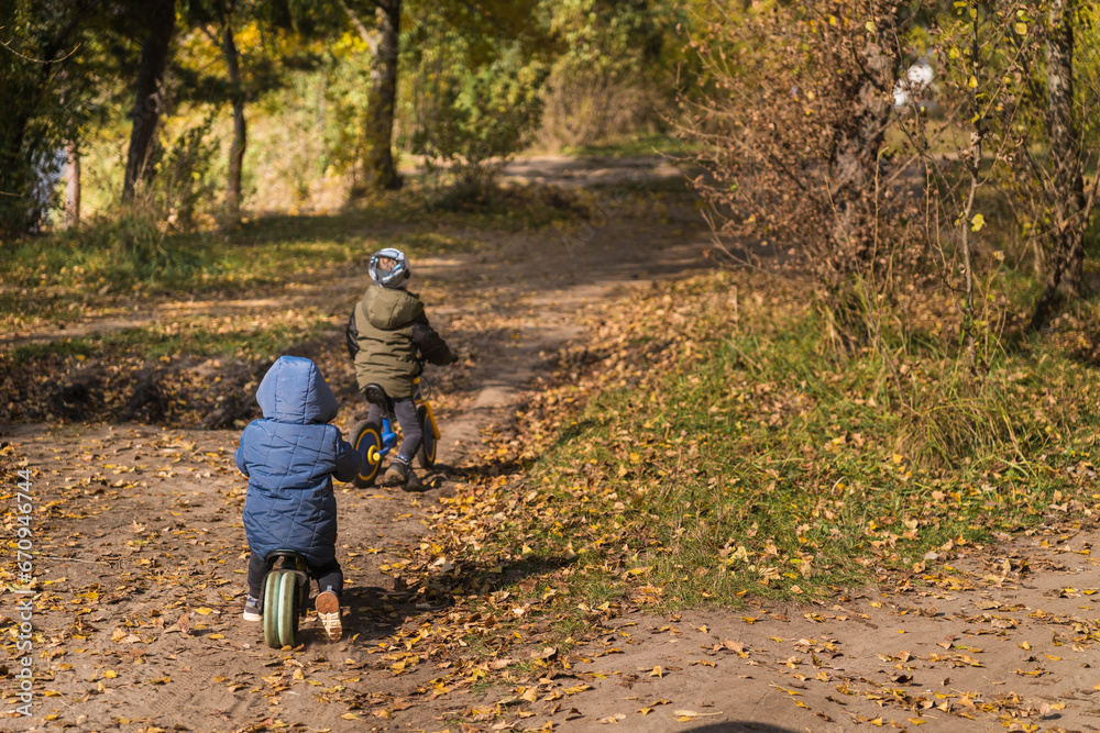 Fototapeta premium Family walking with kids in the autumn forest with yellow bright leaves