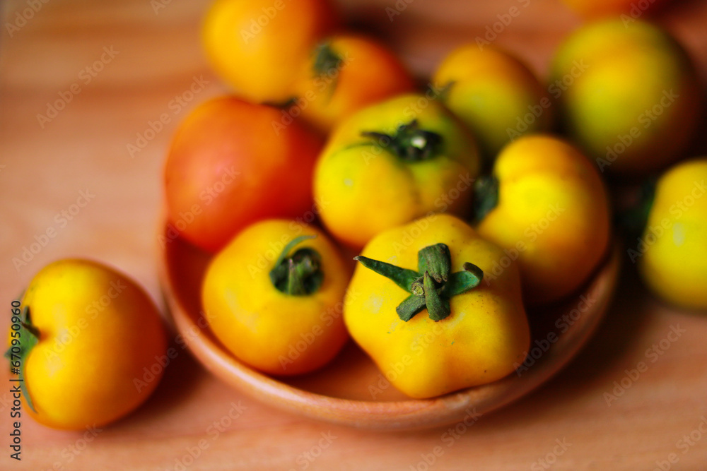 Tomatoes in wooden bowl on wooden table. Selective focus.