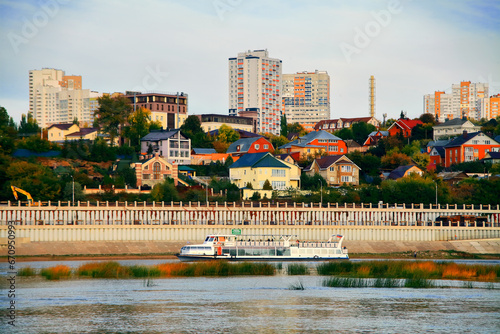 Beautiful view of the city from the Belaya River to the city of Ufa. Motor ships, boats on the water.Translation of the text - "Discounts on an apartment in Ufa" 