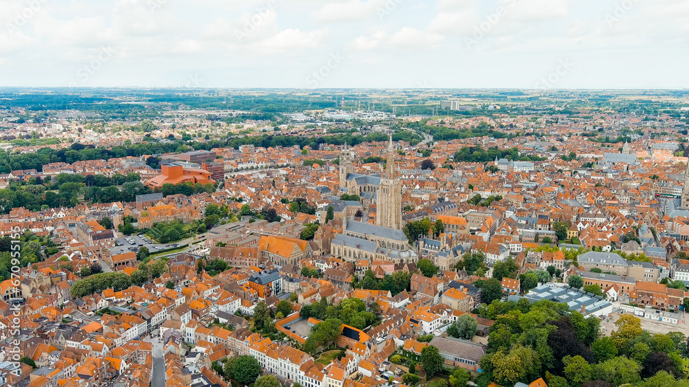 Bruges, Belgium. Church of Our Lady - Gothic church from the 13th century. Panorama of the city center from the air. Cloudy weather, summer day, Aerial View