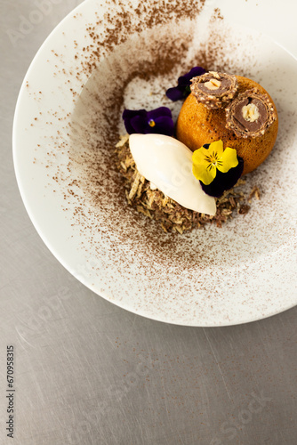Prepared and decorated dessert in white bowl in restaurant kitchen, copy space