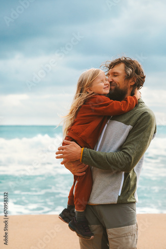 Daughter hugging father family lifestyle outdoor child with dad walking on the beach summer vacations parent and kid love happiness candid emotions
