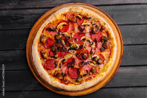 Pepperoni pizza with sausage on wood background