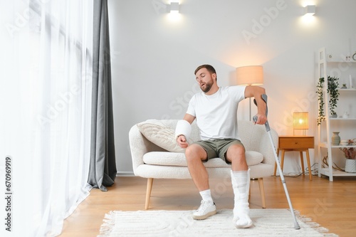 Fotografie Recovery after physical injury in accident at home: Sad unlucky young man with b