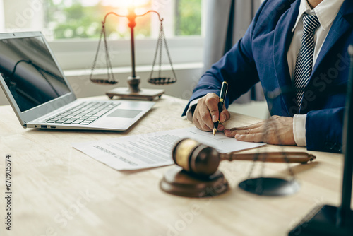 Law and Justice Lawyer working with documents and laptop, hammer, scale at wooden table in office Close-up of judge in suit or lawyer Legal advice and services