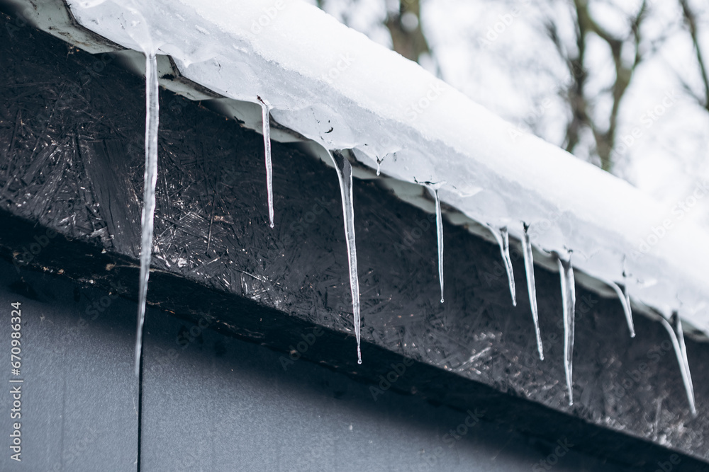 Big sharp melted icicles hang down of snow covered roof in cold winter season. Danger, attention, warning. Frosty day, ice formation
Big sharp melted icicles hang down of snow covered roof in cold winter season. Danger, attention, warning. Frosty day, ice formation