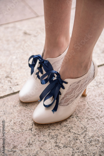 White women's shoes with blue laces and lace