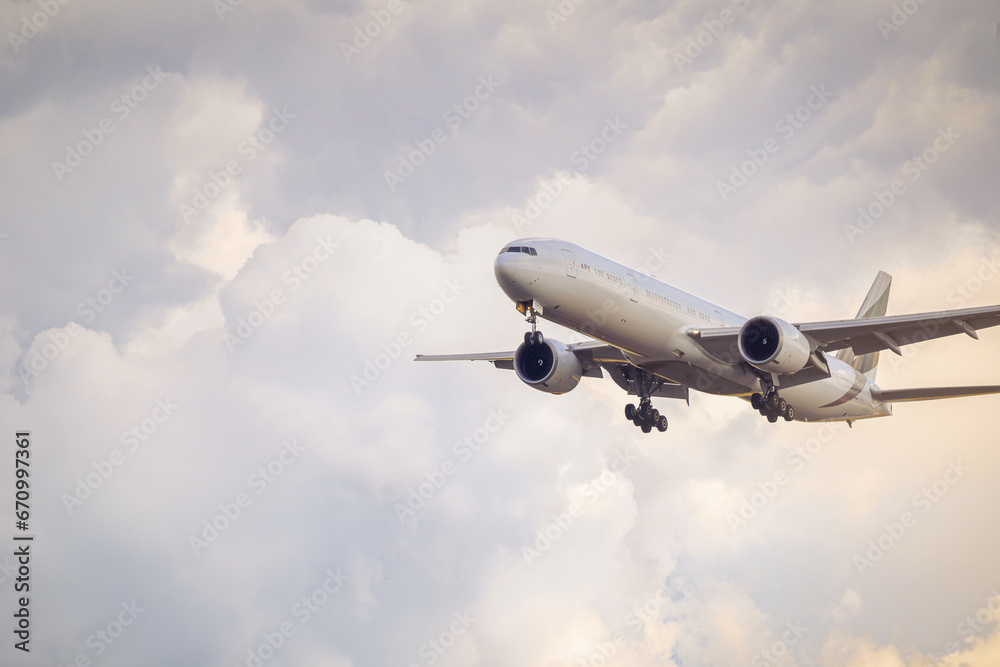 A passenger plane preparing to land amidst the clouds. The light of the setting sun still illuminates. A passenger plane preparing to land amidst the clouds. The light of the setting sun still illuminates.
