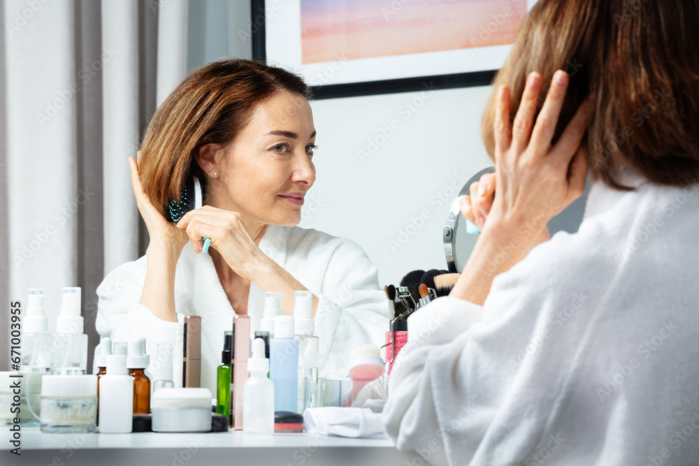 Woman brush hair before makeup mirror at home Woman brush hair before makeup mirror at home