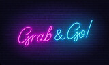 Grab and Go neon sign on brick wall background.