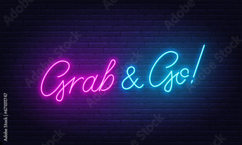 Grab and Go neon sign on brick wall background. photo