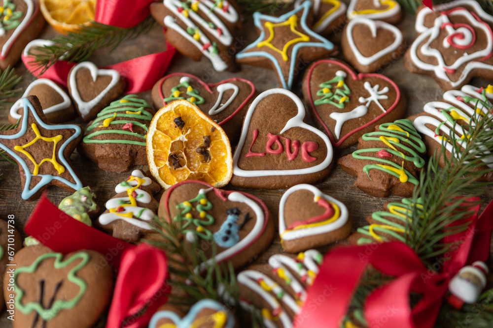 Ręcznie dekorowane ciastka z kolorowym lukrem ułożone na drewnianej desce w świątecznej aranżacji.