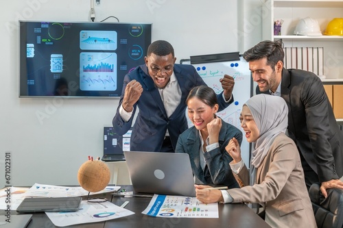 Canvas Print collaboration teamwork partnership multiethnic coworkers look laptop and congratulate happy bravo for win in Online auction biding in office company
