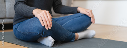 Young woman sitting on the floor and doing meditation practice mindfulness at home