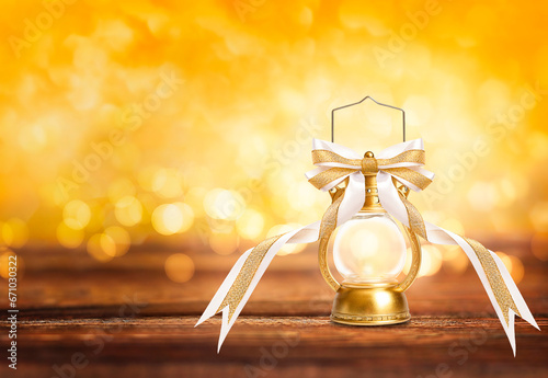 Vintage lantern with golden bow on bokeh background with copy space