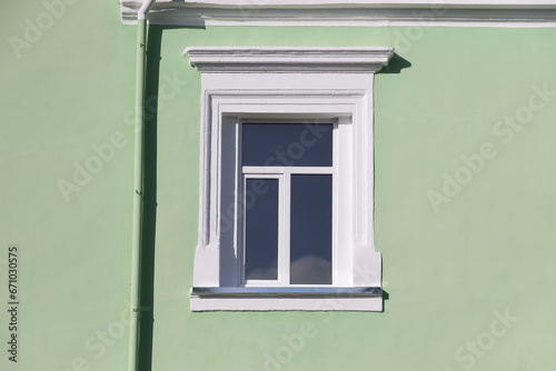 Vintage white window on mint green wall in sunlight close up